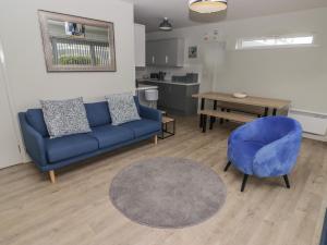 un soggiorno con divano blu e tavolo di 21 Coedrath Park a Saundersfoot