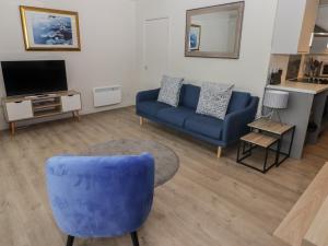 un soggiorno con divano blu e TV di 21 Coedrath Park a Saundersfoot