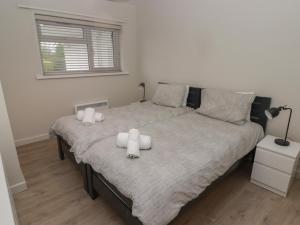 una camera da letto con un grande letto con asciugamani bianchi di 21 Coedrath Park a Saundersfoot