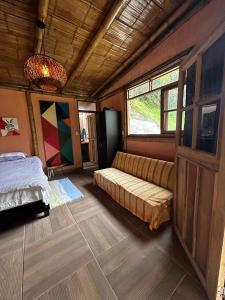 伊瓦格的住宿－Cabaña Canto de las Aguas Cañón del Combeima，一间卧室配有一张床和一张沙发