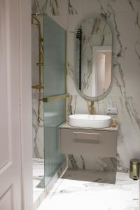 a bathroom with a sink and a mirror at Srebrna Luxury Apartments - willa fabrykancka in Łódź