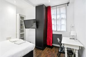 a bedroom with a bed and a desk and a television at Stylish 2 bedroom apartment in Shoreditch - London in London