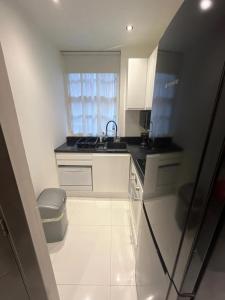 a kitchen with white cabinets and a sink and a window at Stylish 2 bedroom apartment in Shoreditch - London in London