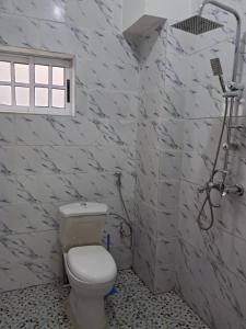 La salle de bains est pourvue d'une douche et de toilettes. dans l'établissement APPARTEMENT NEW STANDING CITE CHIRAC YASSA, à Yapoma