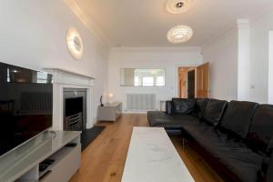 uma sala de estar com um sofá e uma televisão em Luxury Penthouse on The Scores - Best View in St Andrews em St. Andrews