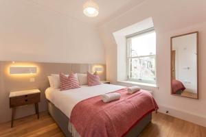 a bedroom with a large bed and a window at Luxury Penthouse on The Scores - Best View in St Andrews in St Andrews