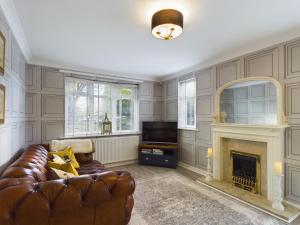 a living room with a couch and a fireplace at Exquisite Bungalow in Hessle