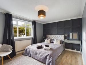 a bedroom with a bed with black walls and a window at Exquisite Bungalow in Hessle