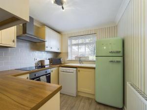 a kitchen with a green refrigerator and a sink at Exquisite Bungalow in Hessle