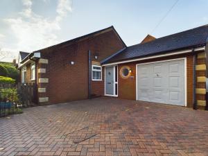 a brick house with a garage and a driveway at Exquisite Bungalow in Hessle