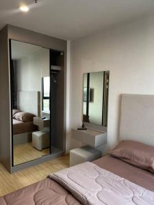 een slaapkamer met een bed en een grote spiegel bij The Cozy, 3 min walk to MRT, 2 STN to Royal Palace in Bangkok Yai