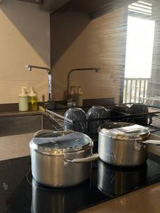 three pots sitting on top of a stove in a kitchen at The Cozy, 3 min walk to MRT, 2 STN to Royal Palace in Bangkok Yai