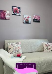 ein Wohnzimmer mit Sofa und ein paar Bildern an der Wand in der Unterkunft B&B ANASTASIA in Pompei