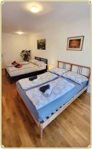 two beds in a room with wooden floors at Sunshine Vienna in Vienna