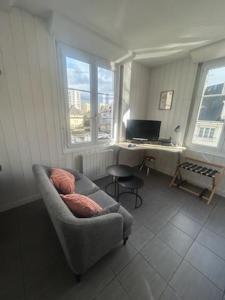 un salon avec une chaise et un bureau avec un ordinateur dans l'établissement Sirius - SILS, à Caen