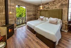 two beds in a room with a wood stove at Ecocasa Lema II in Muxia +70 photos