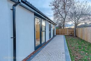 a house with a walkway next to a fence at Balloon Suite: Modern Luxury in Bristol