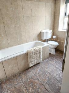 a bathroom with a bath tub and a toilet at The New Inn in Yeovil