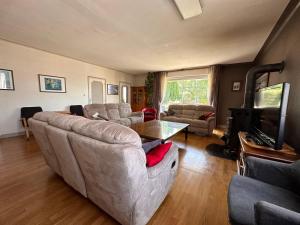 uma sala de estar com um sofá e uma mesa em Grande maison familiale au calme en ville em Saint-Brieuc
