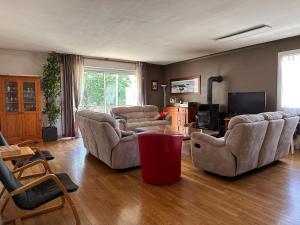 uma sala de estar com dois sofás e uma televisão em Grande maison familiale au calme en ville em Saint-Brieuc