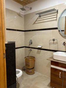 a bathroom with a toilet and a sink and a mirror at HOTEL MA HEIGHTS in Dalhousie