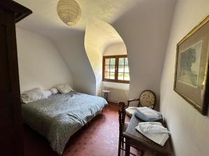 Clohars-Fouesnant的住宿－Maison familiale pour des vacances nature en bord de mer à Bénodet，一间卧室配有一张床、一张桌子和一个窗户。