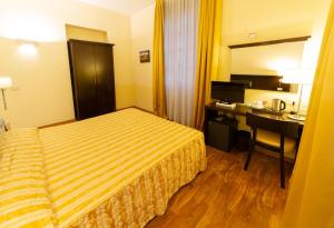 a hotel room with a bed and a desk at Hotel Due Colonne in Cagliari