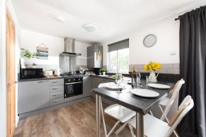 a kitchen with a table and chairs in a kitchen at Wheal Amelia Lodge in Helston
