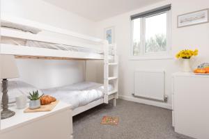 a bedroom with two bunk beds and a window at Wheal Amelia Lodge in Helston