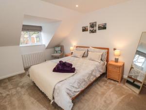 a bedroom with a large bed and a mirror at Martindale Cottage in Whitby