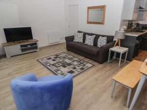 sala de estar con silla azul y sofá en 19 Coedrath Park en Saundersfoot