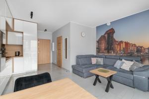 a living room with a blue couch and a table at Cosmo Apartments in Gdańsk