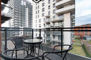 een balkon met stoelen en een tafel in een gebouw bij Cosmo Apartments in Gdańsk
