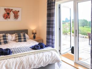 a bedroom with a bed and a sliding glass door at Pine Marten in Dornoch