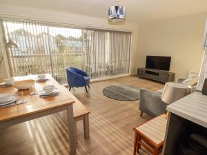 a living room with a table and chairs and a television at 36 Coedrath Park in Saundersfoot
