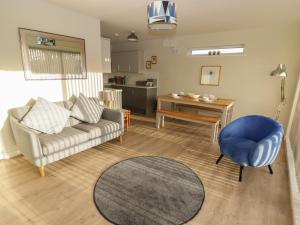 a living room with a couch and a chair and a table at 36 Coedrath Park in Saundersfoot