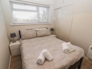 a bedroom with a bed with white towels on it at 36 Coedrath Park in Saundersfoot