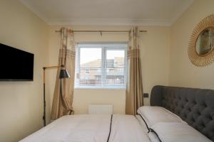 1 dormitorio con cama y ventana en Beach Retreat, en Seaford