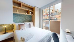 a bedroom with a bed and a desk and a window at The Cabrera Eighty Fifth Hotel in Bogotá