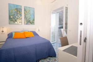 a bedroom with a blue bed with orange pillows at DOMUS LINA in Sorrento