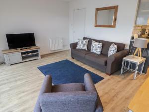 a living room with two couches and a tv at 28 Coedrath Park in Saundersfoot