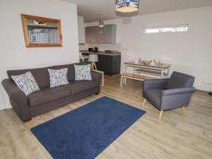 a living room with a couch and a chair at 28 Coedrath Park in Saundersfoot