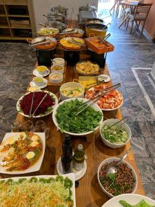 a table filled with lots of different dishes of food at Ninety Hotel in Sao Paulo