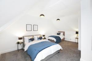 2 camas en un dormitorio con paredes blancas en Beautiful House in Nottingham w/ Parking & WiFi - Sleeps 10 by PureStay Short Lets, en Nottingham