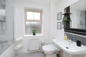 a white bathroom with a sink and a toilet at Beautiful House in Nottingham w/ Parking & WiFi - Sleeps 10 by PureStay Short Lets in Nottingham