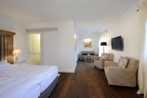 een slaapkamer met een bed en een woonkamer bij Boutique Hotel Relais Chalet Wilhelmy in Bad Wiessee