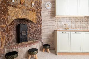 cocina con chimenea de piedra y taburetes en Giannis House en Rodas