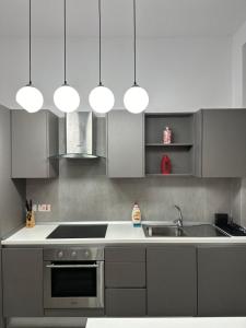 a kitchen with gray cabinets and a sink and lights at Sea View Villa in Sliema