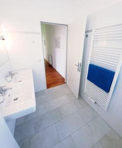 ein weißes Badezimmer mit einem Waschbecken und einem Spiegel in der Unterkunft Art of Simmering in Wien