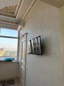 een kamer met een raam en een tv aan de muur bij The Rudaki Home stay in Doesjanbe